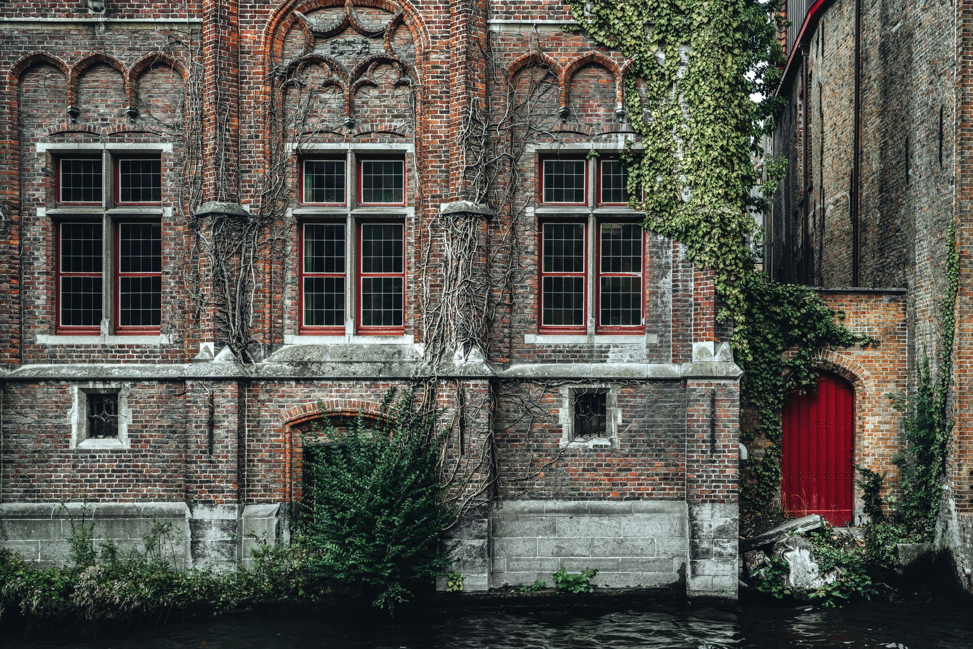Fragment of exterior of ancient historic brick building with ornamental walls located on Steenhouwers Canal in Bruges