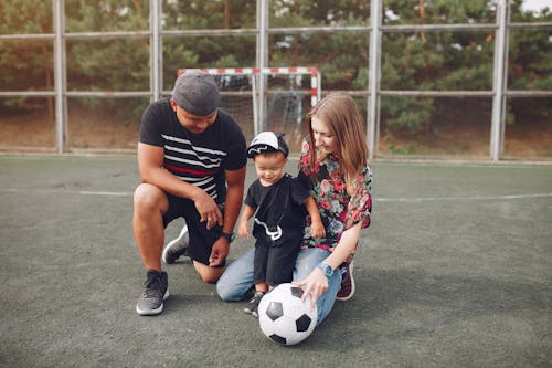 Happy family on football field with ball