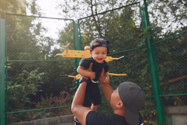 Father Holding Laughing Son In Air