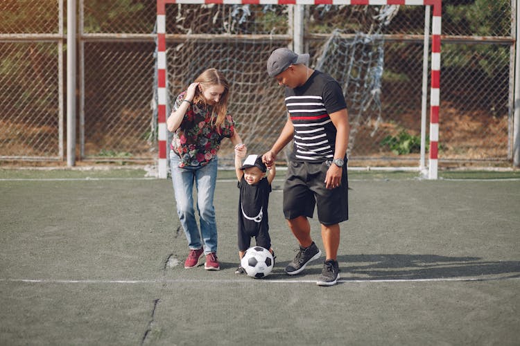 Content Family With Toddler Boy On Football Field