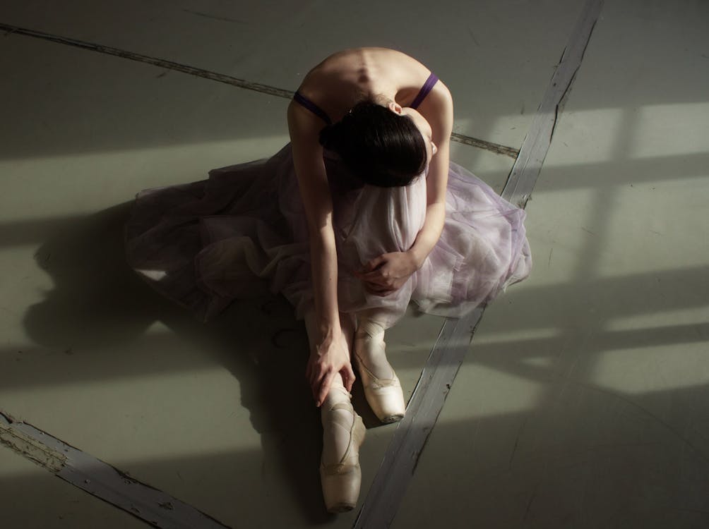 不可識別的優雅芭蕾舞演員在地板上休息