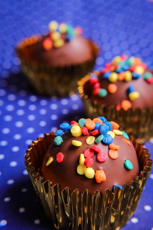 Free From above of delicious homemade cupcakes covered with chocolate frosting and decorated with colorful sprinkles Stock Photo