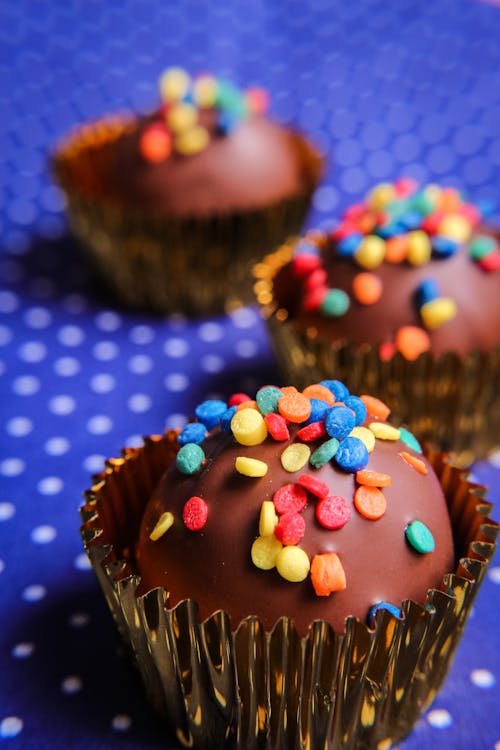 From above of delicious homemade cupcakes covered with chocolate frosting and decorated with colorful sprinkles