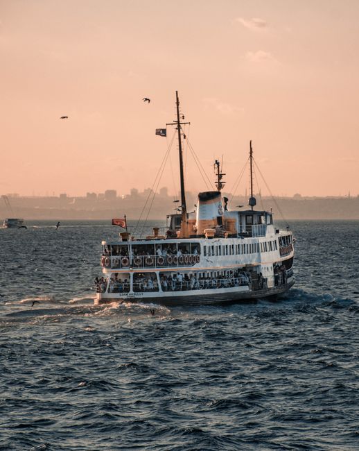 Modern vessel floating on rippling sea water during cruise trip against pink sunset sky