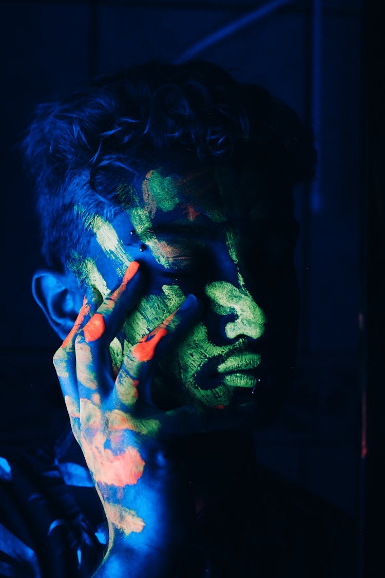 Serious Ethnic Male With Neon Makeup In Ultraviolet Light