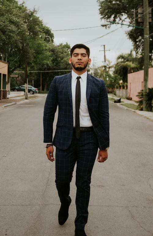 Free Full body of young confident ethnic businessman with beard and wristwatch in elegant suit looking at camera while walking to work through street Stock Photo