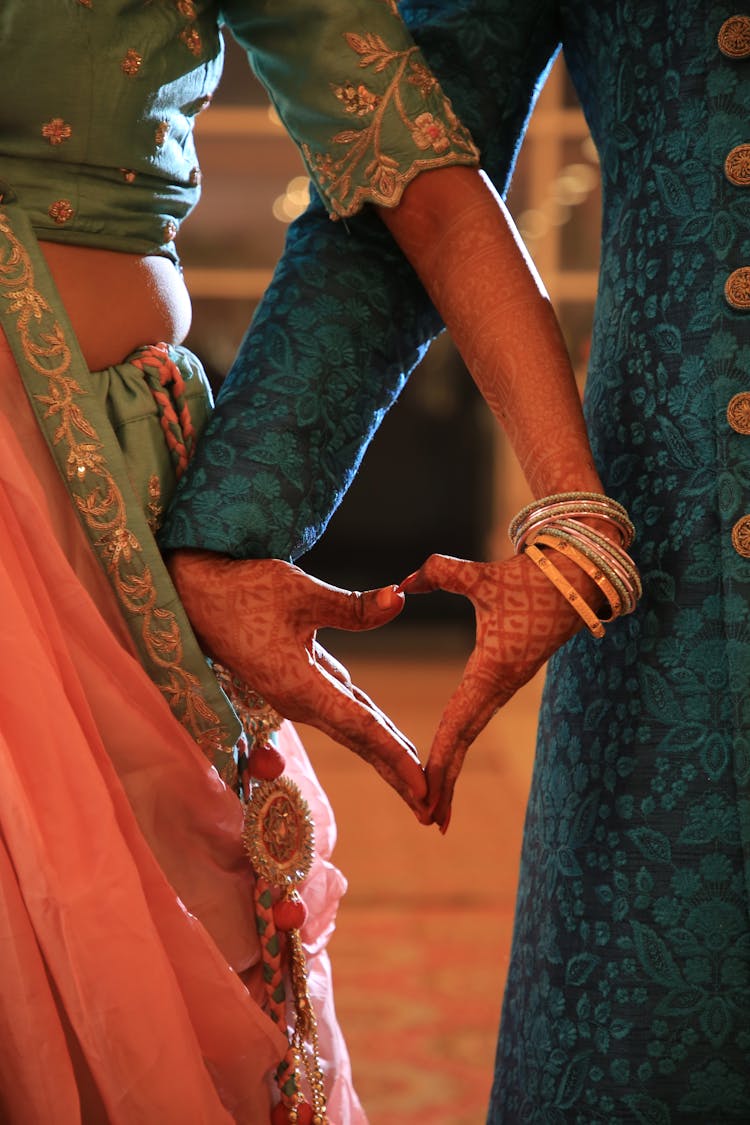 Bride And Groom Making A Heart With Their Hands