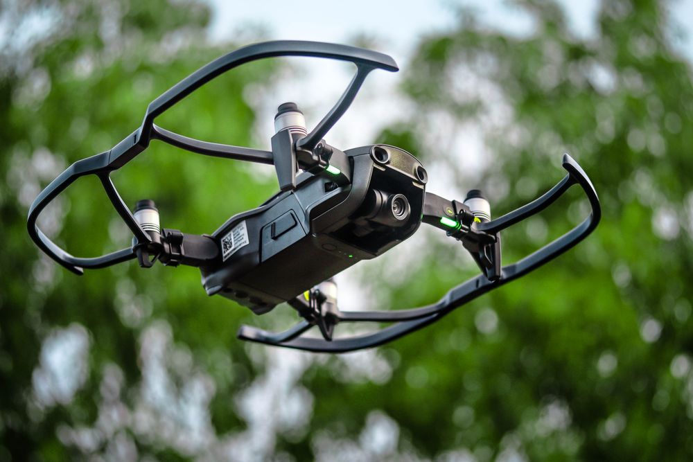 Close pass of the filming drone against foliage