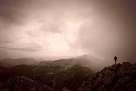 Silhouette of a man standing on a mountain ridge under a cloudy sky in Slovakia.