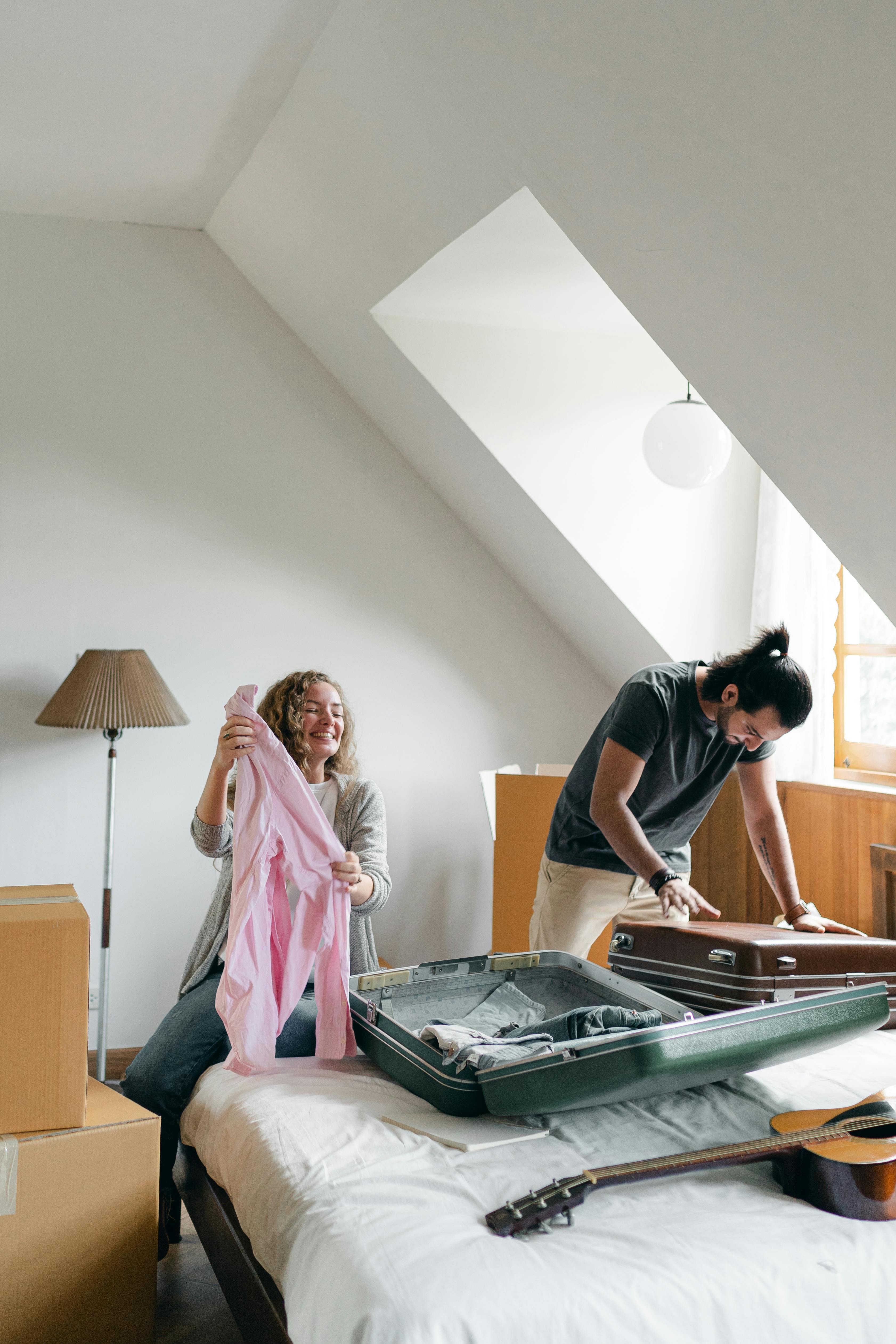 cheerful couple packing suitcases and carton boxes