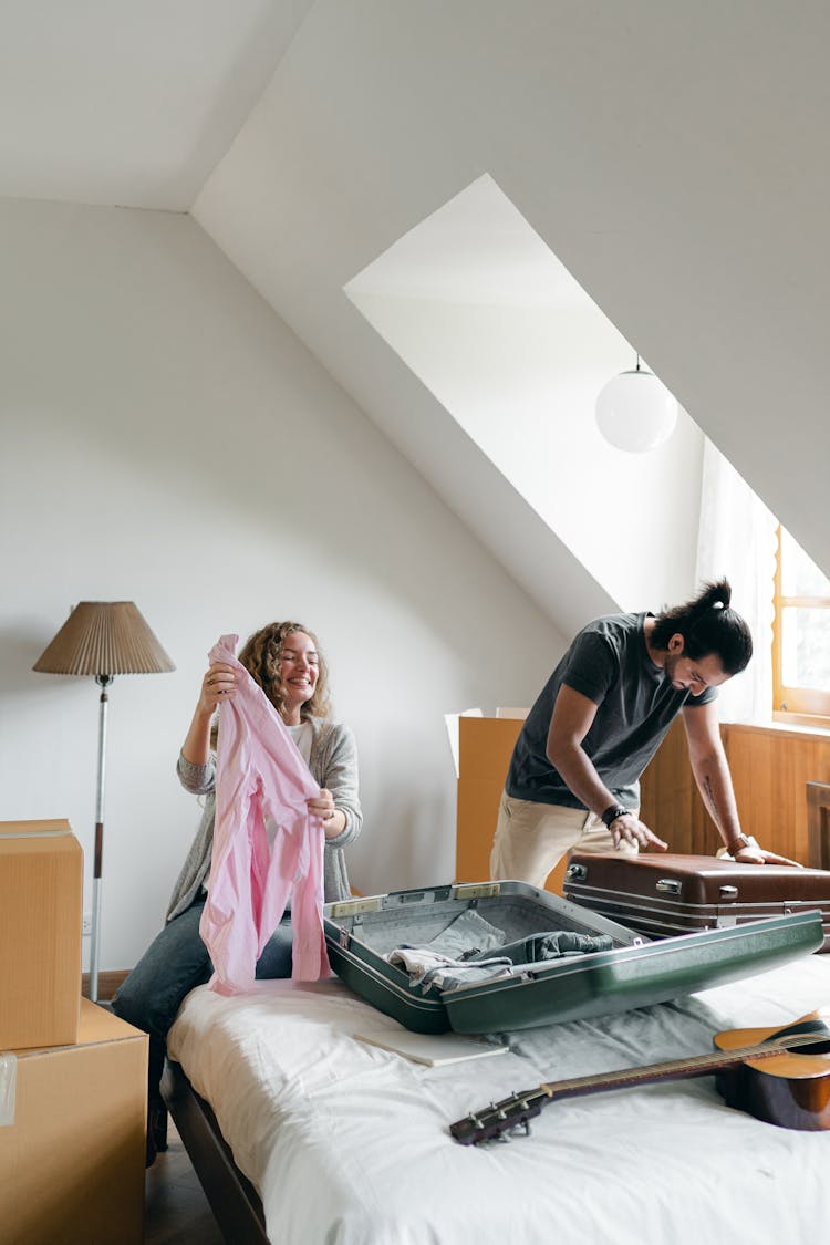 Cheerful Couple Packing Suitcases And Carton Boxes