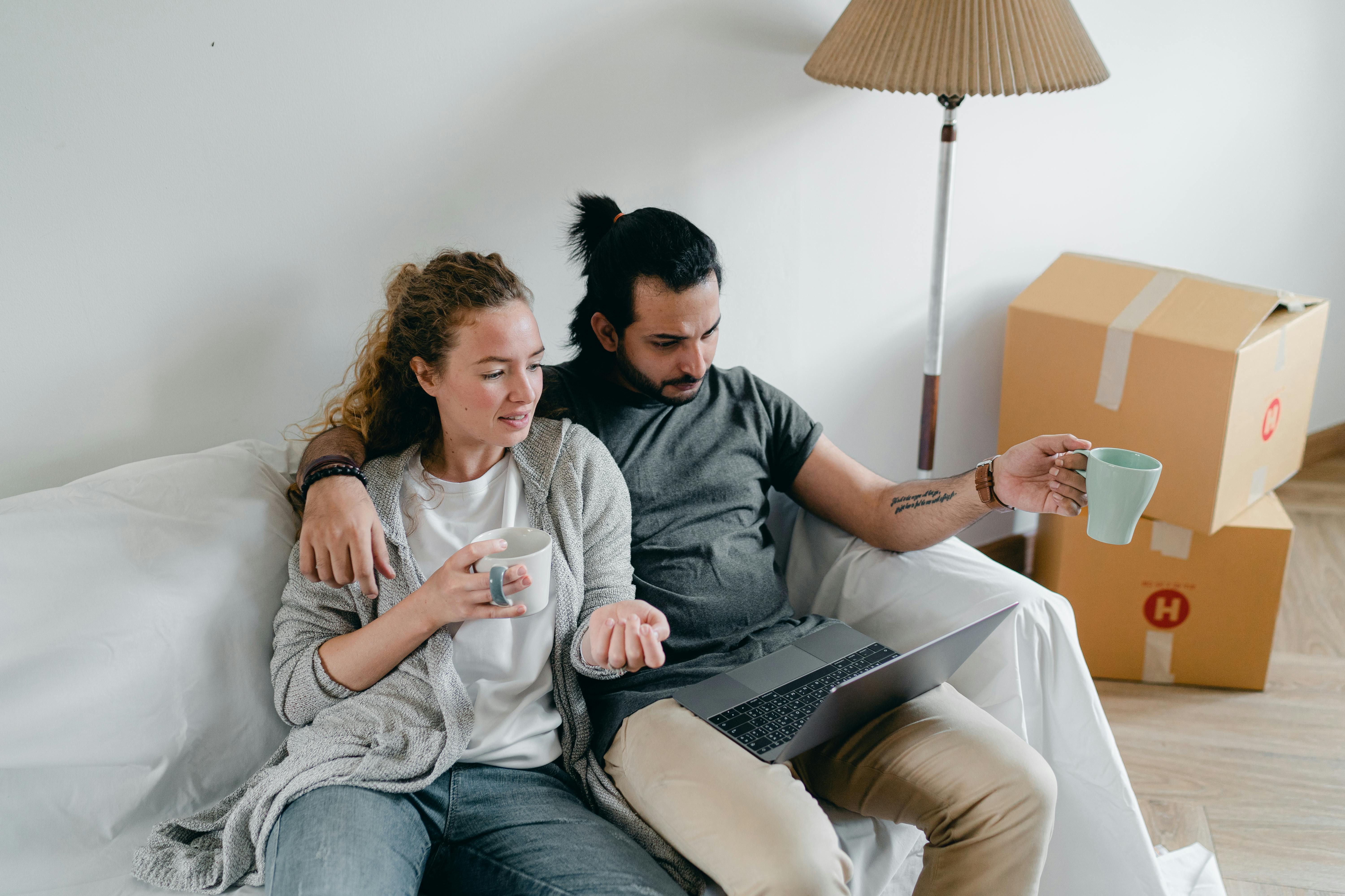 bonding couple browsing laptop after packing carton boxes