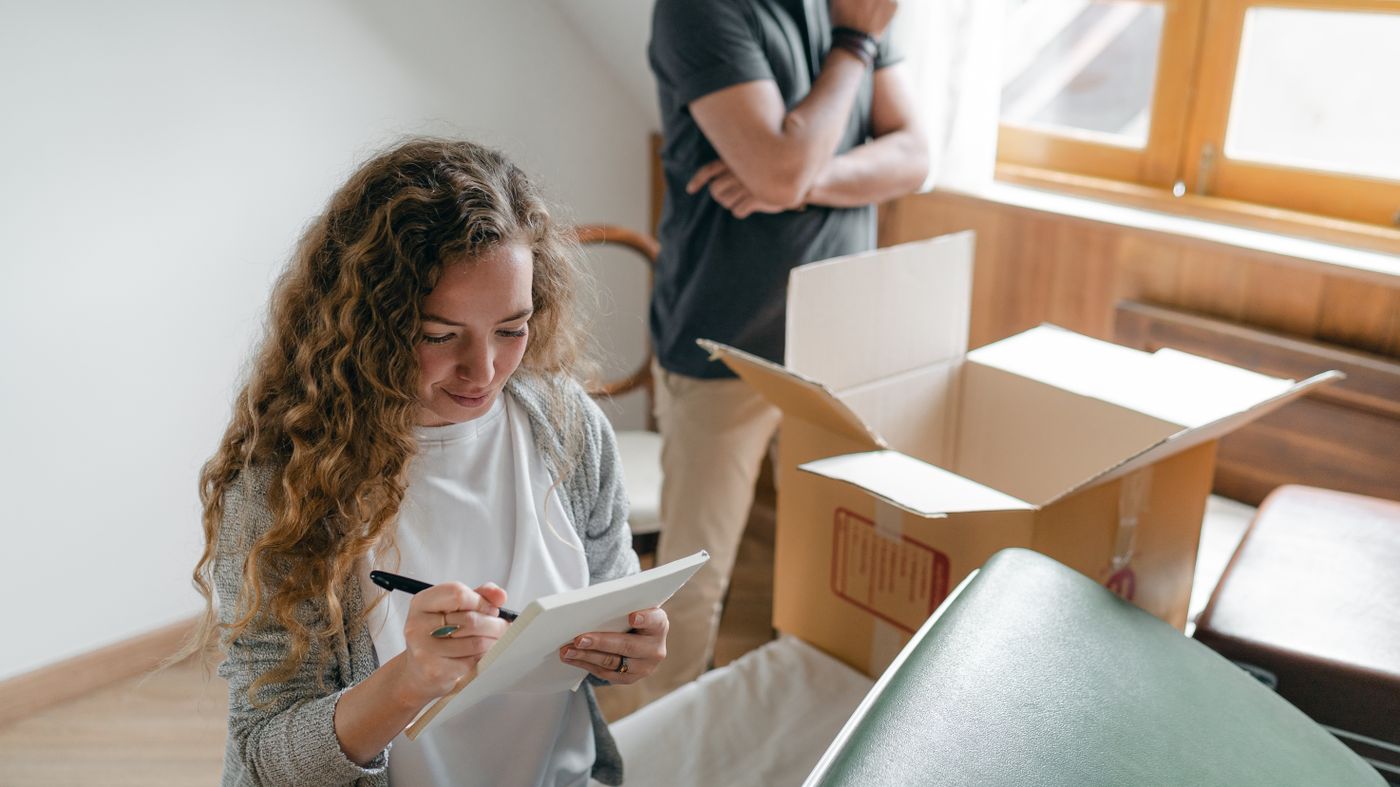 Homeowner calmly writing a damage checklist at home while documenting belongings after property damage