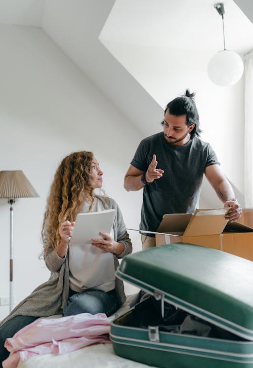 Couple preparing baggage for moving according to checklist