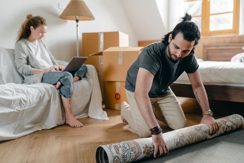 Laying a rug in a compact bright bedroom