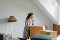 一名女子在安静的阁楼里，正考虑如何搬动那些箱子