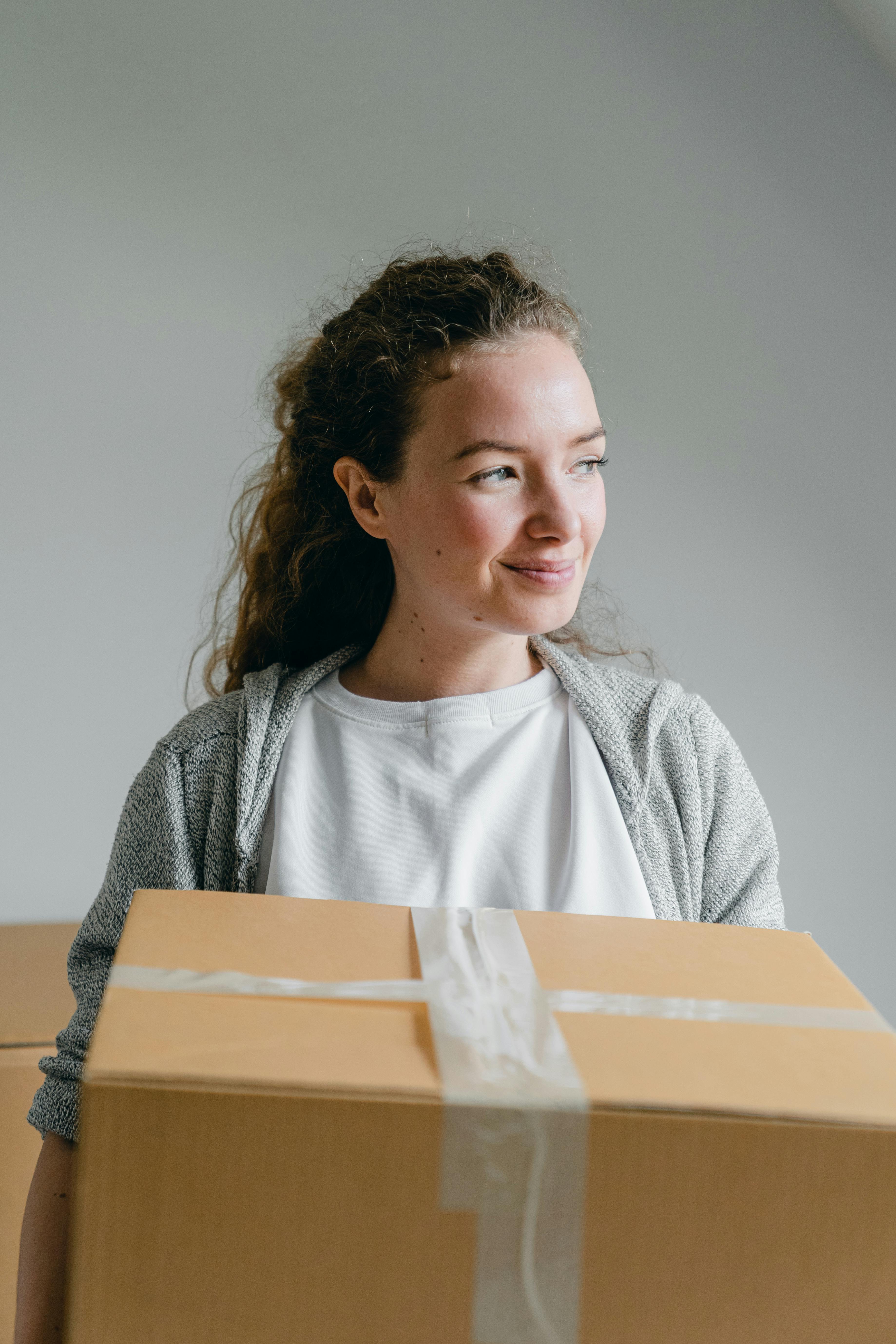 smiling woman with carton box looking away