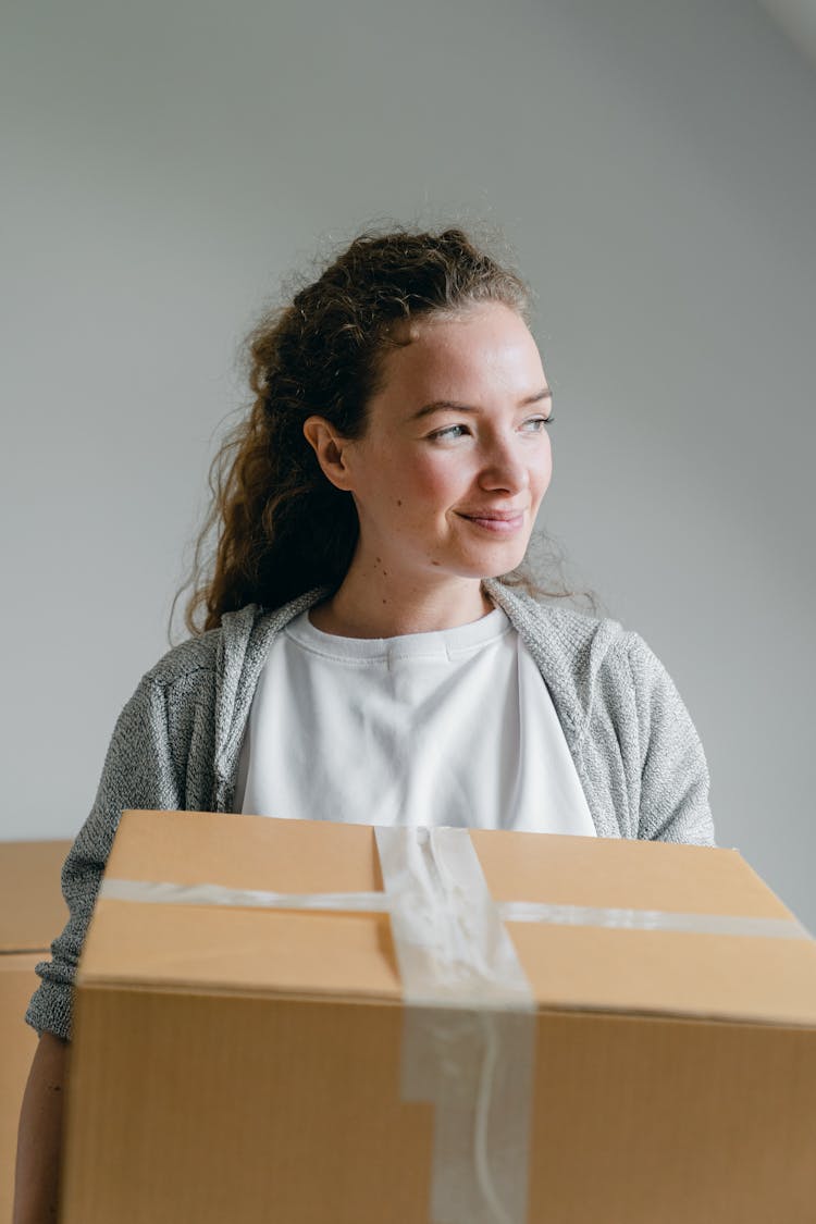 Smiling Woman With Carton Box Looking Away