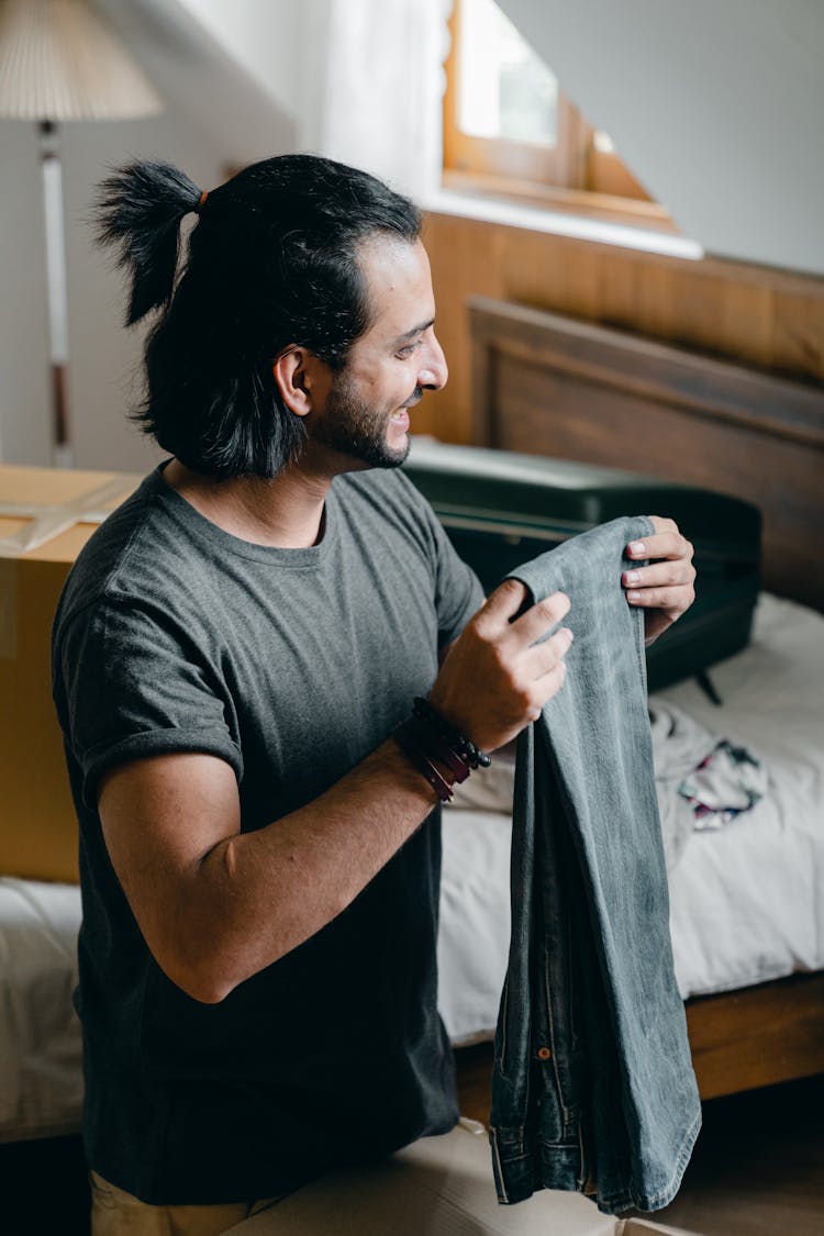 Cheerful Adult Man Unpacking Boxes During Relocation In New House