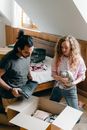 Diverse man and woman unpacking stuff while relocating to new apartment