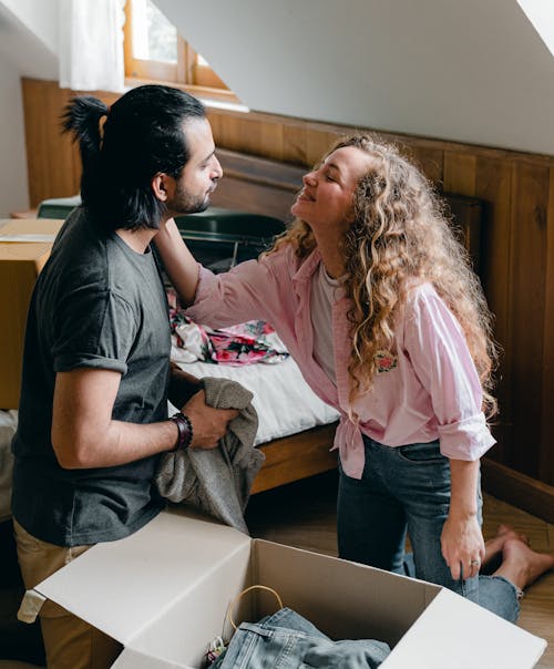 Happy diverse man and woman unboxing stuff while relocating in new apartment
