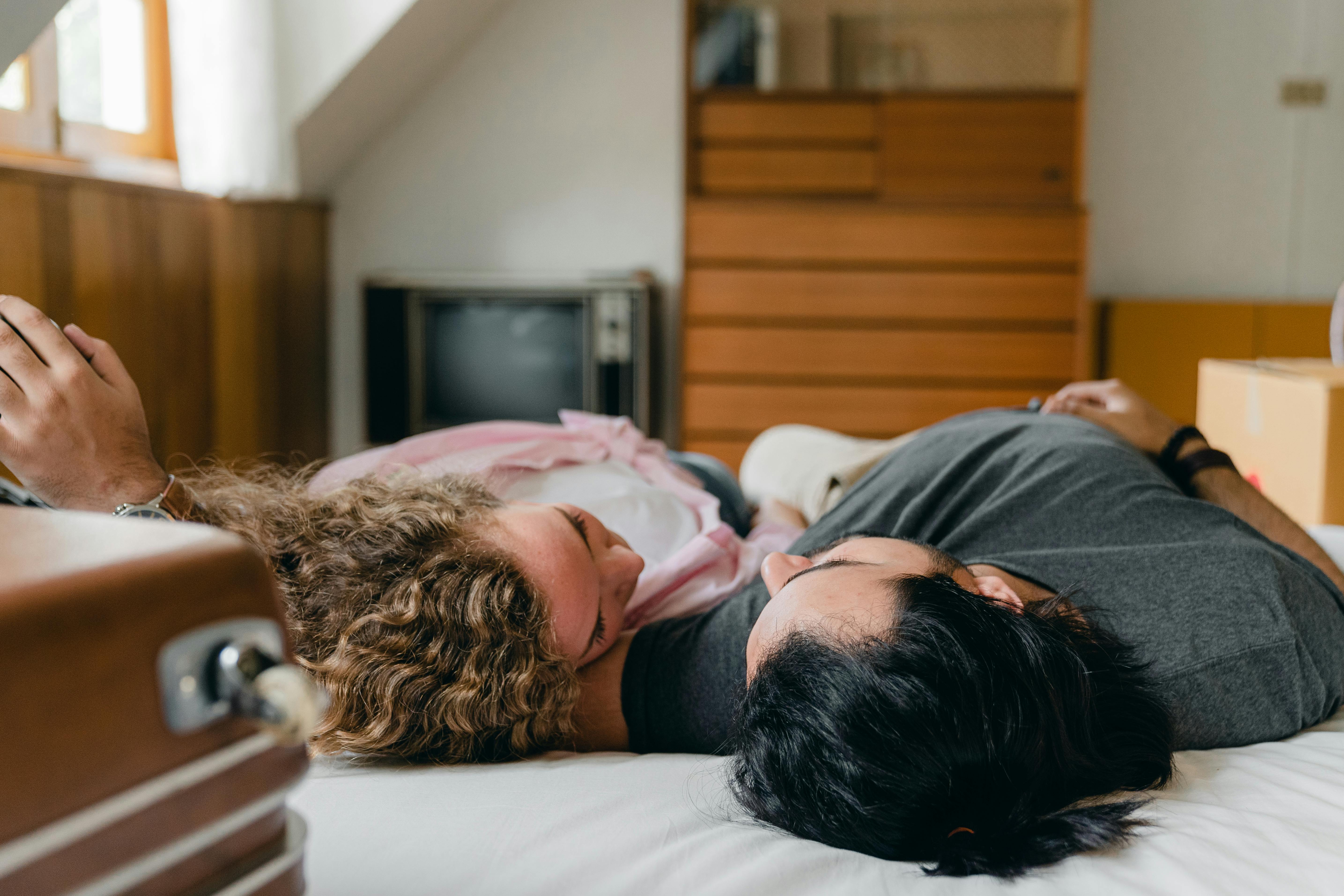 young diverse couple sleeping together at home