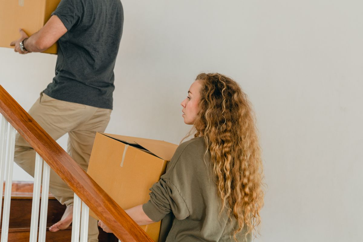 People carrying moving boxes upstairs