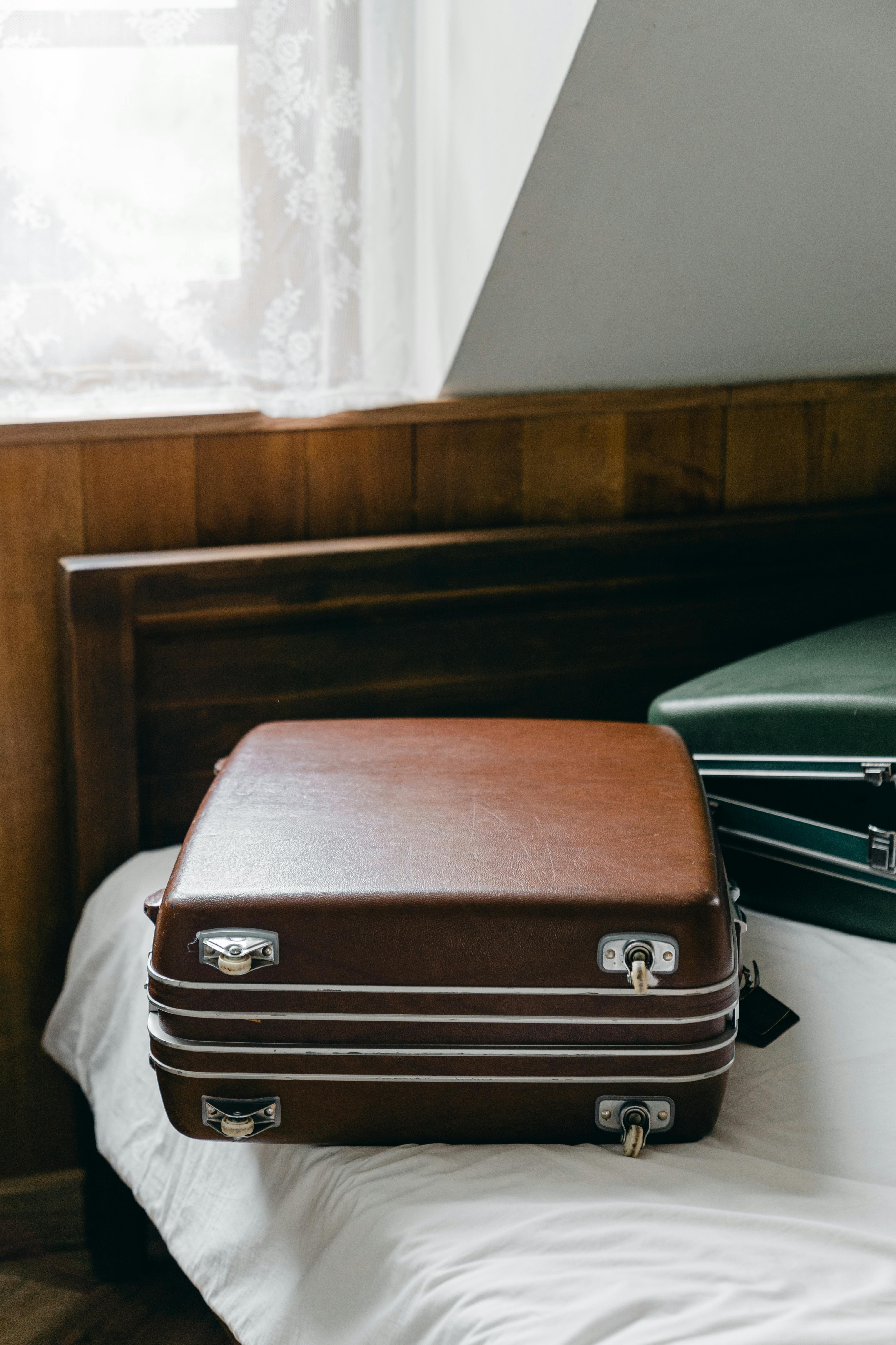 suitcases placed on edge of bed