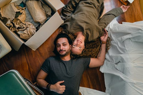 Cheerful couple resting on floor after relocation