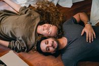 Cheerful couple lying on floor together