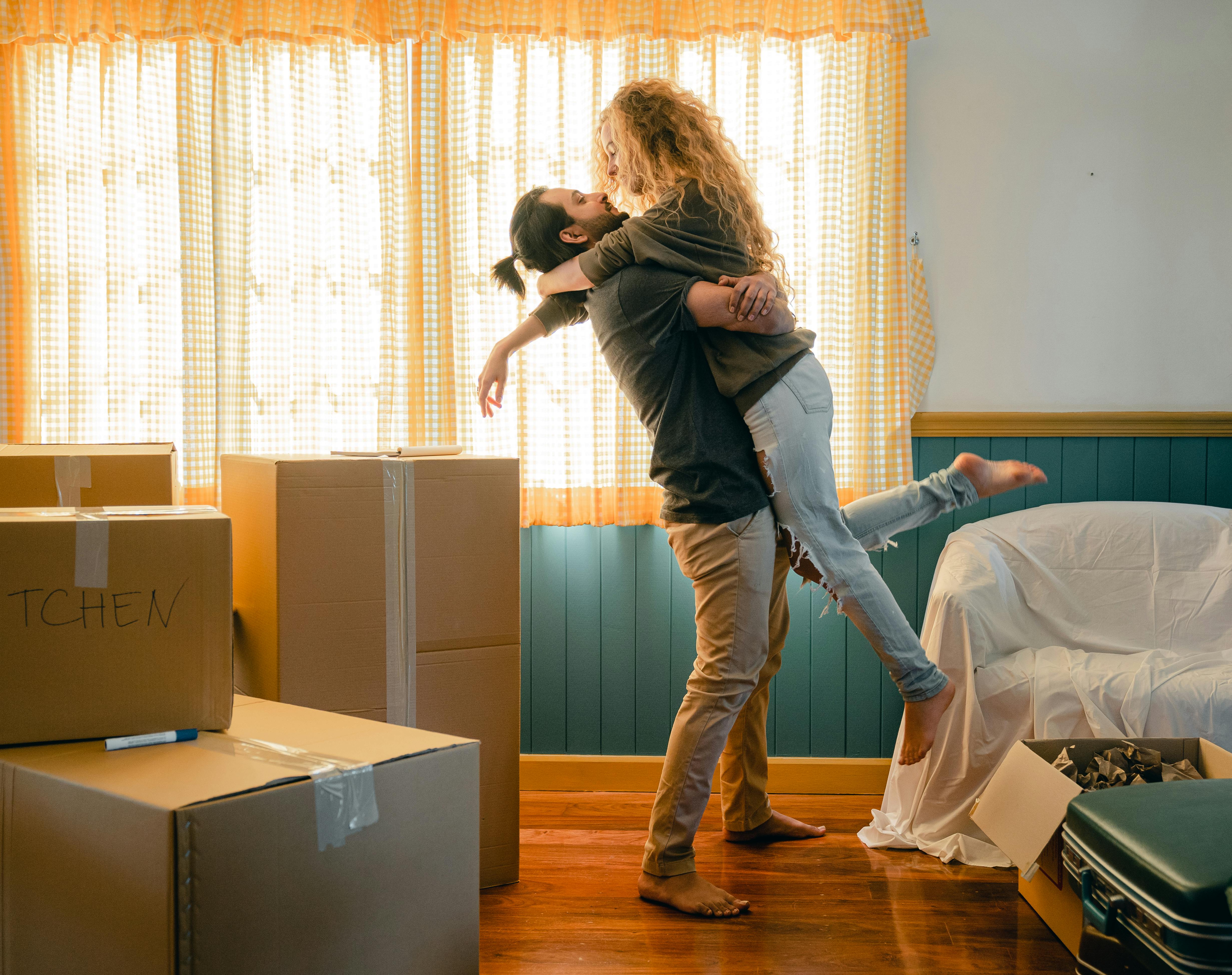 happy couple boding and unpacking boxes in new home