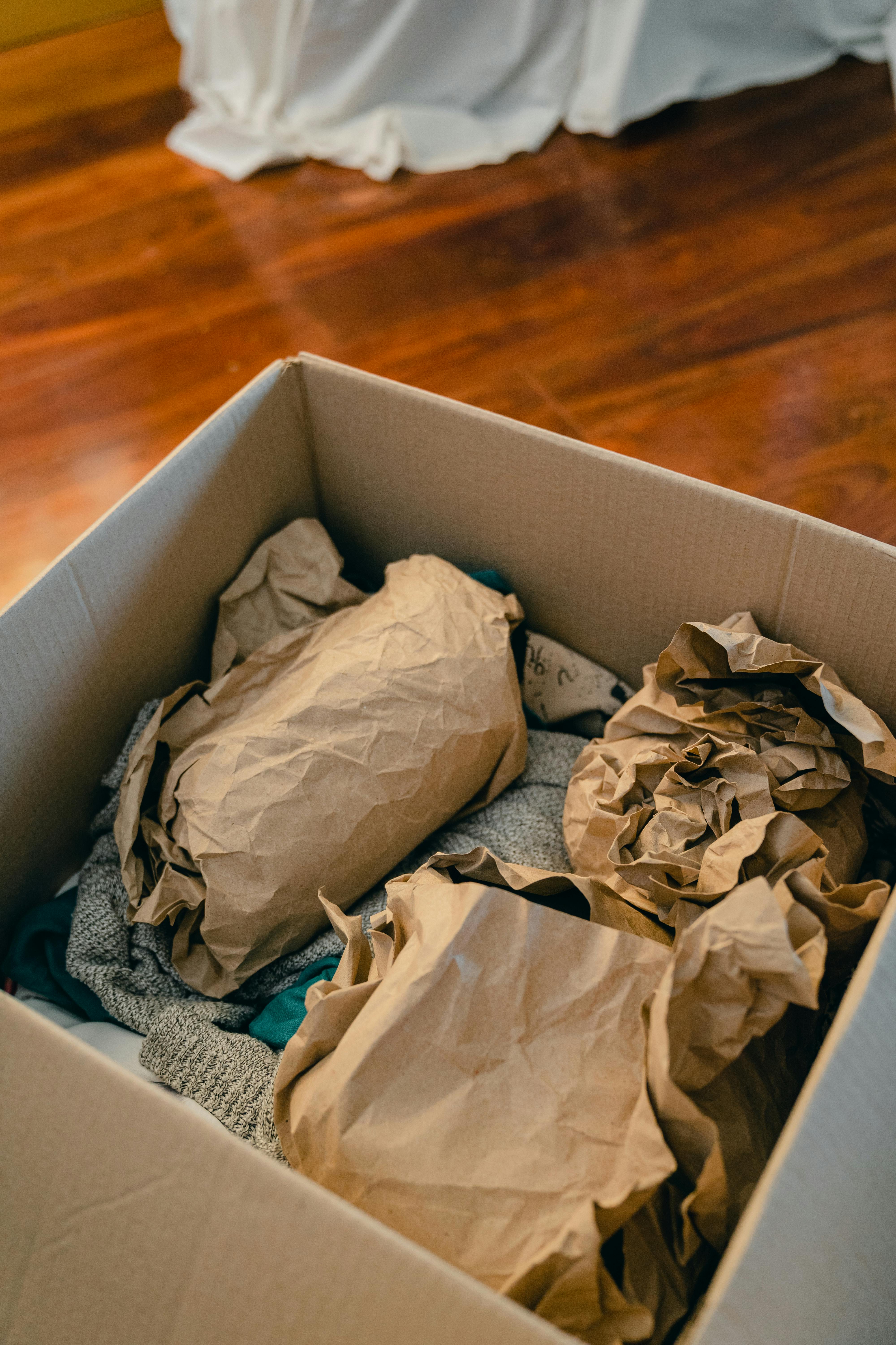 box with objects wrapped in brown paper for moving