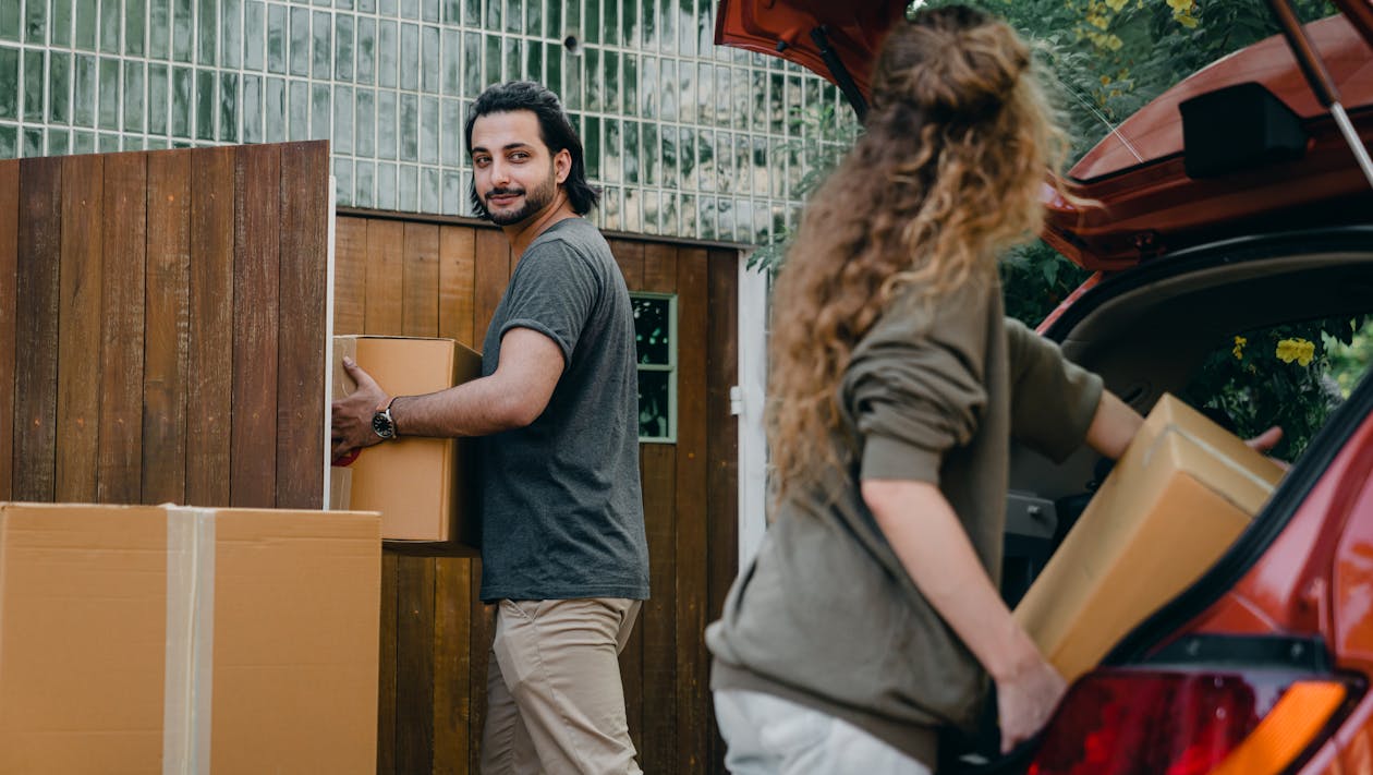 Free Couple in yard unloading car while moving house Stock Photo