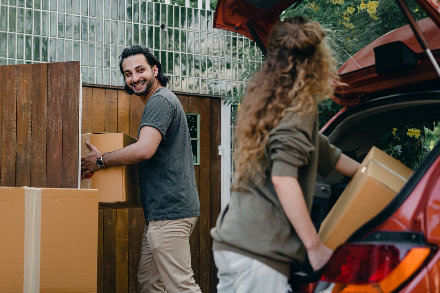 Neighbors loading boxes into a car for a short haul