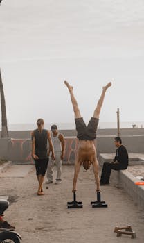 Athletic group performing outdoor calisthenics on a sunny day by the Venice Beach promenade.