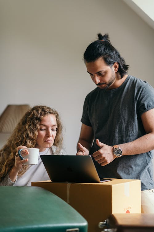 Free Young couple buying things for new house online using laptop Stock Photo