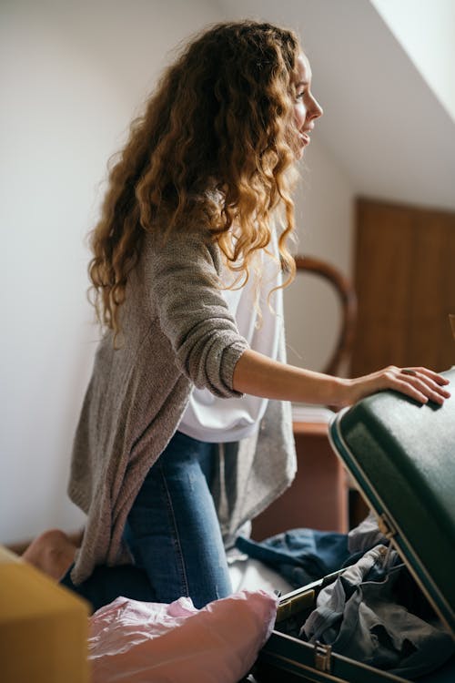 Free Focused woman packing suitcase in bedroom Stock Photo