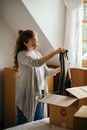 Peaceful woman carefully packing carton boxes