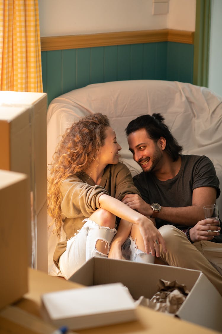 Happy Diverse Couple Unpacking Boxes While Relocating In New House