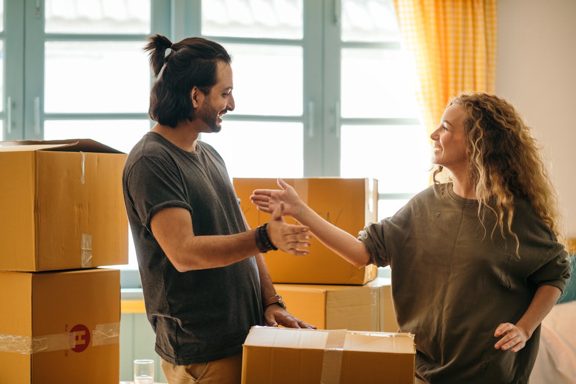 Free Happy diverse couple among carton boxes in new home Stock Photo