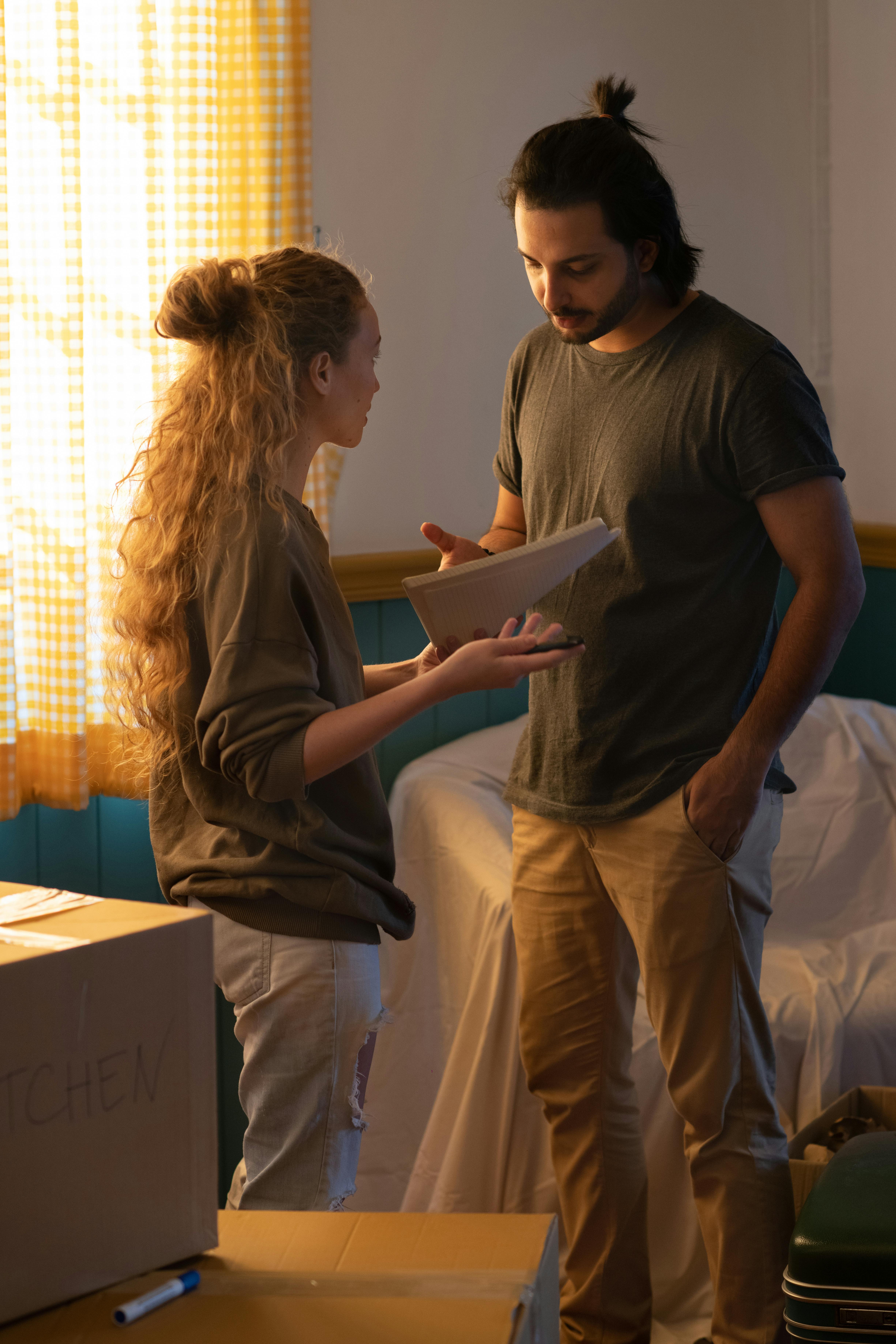 couple talking in new house room with moved personal items