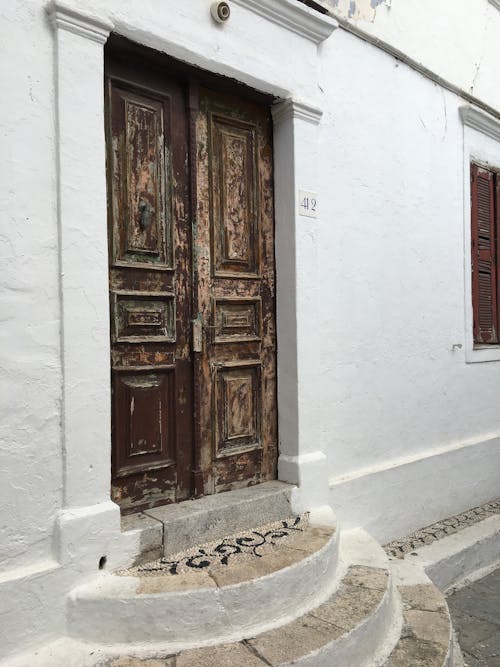 Free Derelict Brown Wooden Door on White Concrete Wall Stock Photo