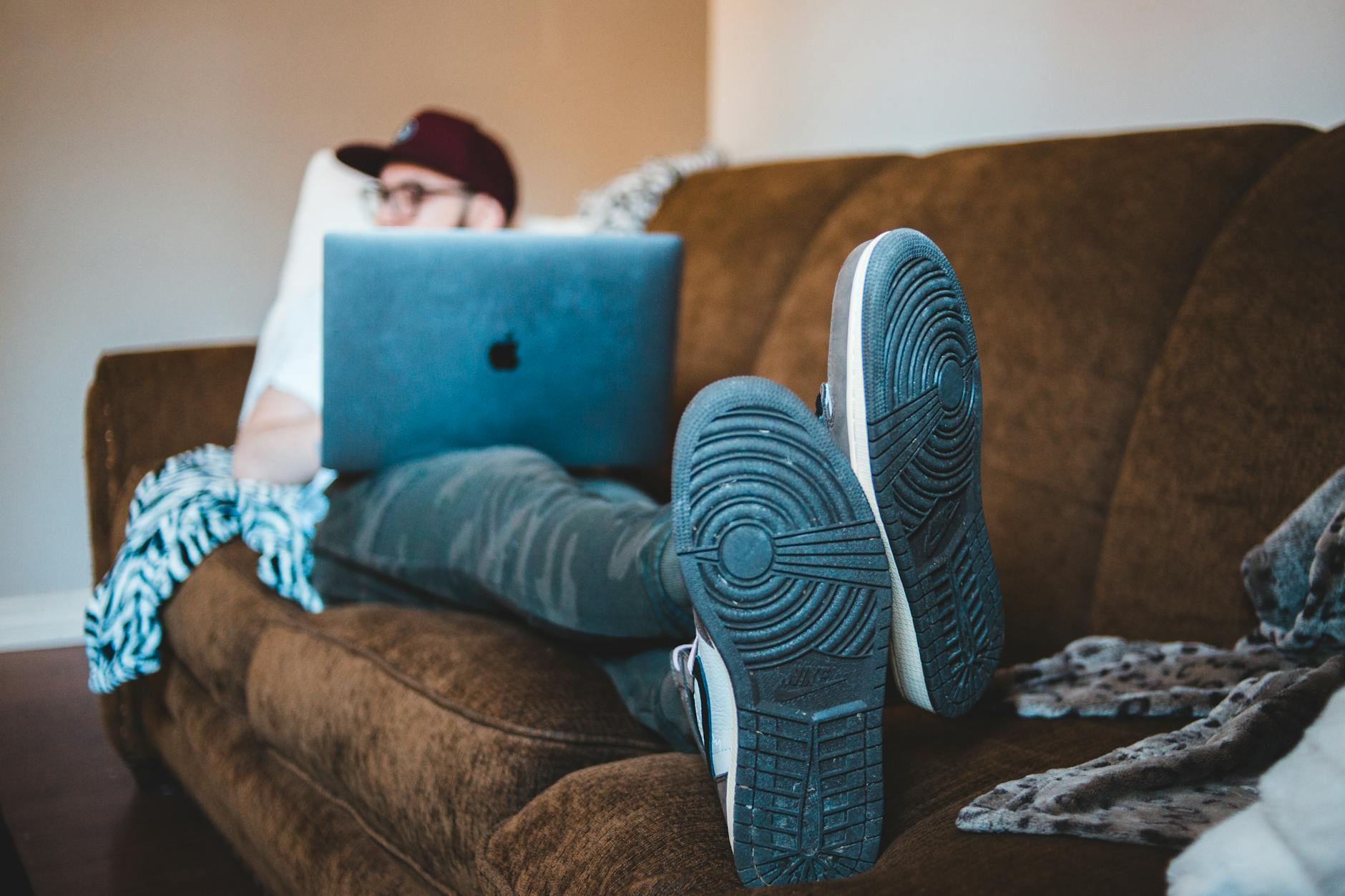 Unrecognizable man with laptop resting on cozy sofa at home · Free ...