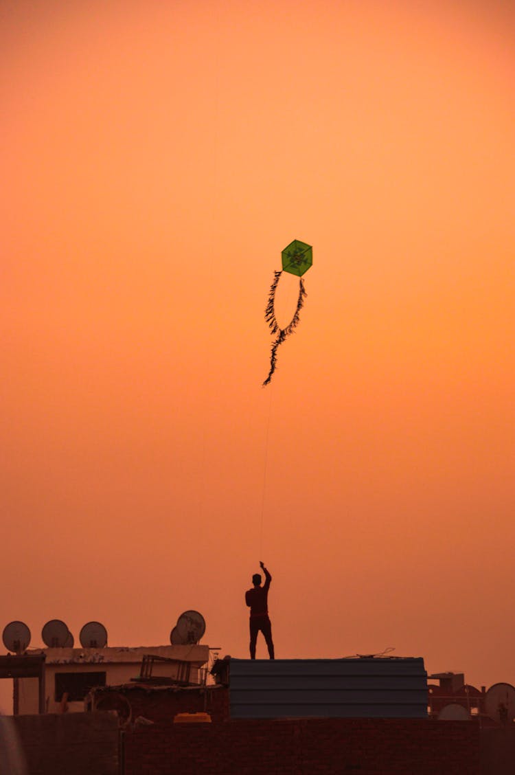 Silhouette Of Person Flying A Kite