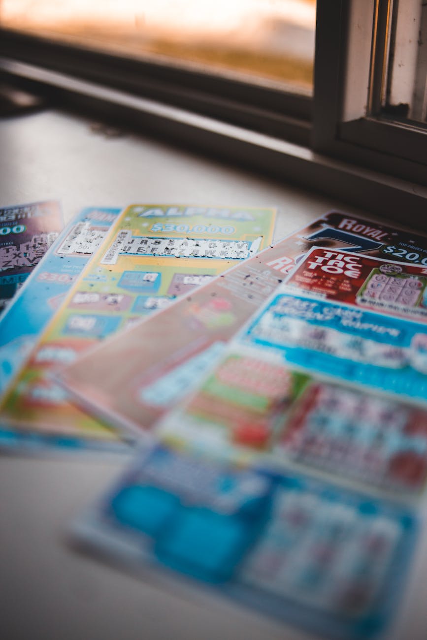 UAEThrive Daily News Roundup:Vivid close-up of assorted lottery tickets on a table near a window, showcasing gambling concepts.