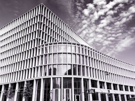 在阴沉的天空下，采用玻璃和钢立面的当代城市建筑展现了现代建筑风格