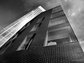 现代摩天大楼低角度视角，反光玻璃窗与黑白砖砌立面相映成趣