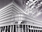 这是一张黑白照片，展示了一座具有玻璃立面和独特设计的现代建筑