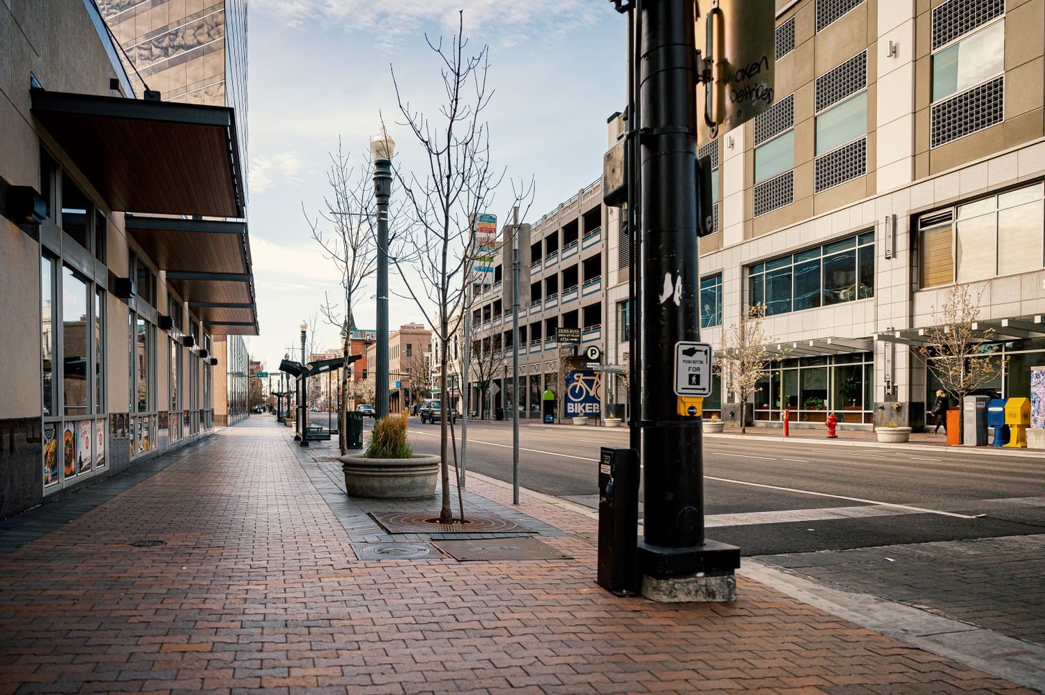 Empty brick sidewalk running past downtown storefronts on an autumn morning — photo by Brett Sayles on Pexels