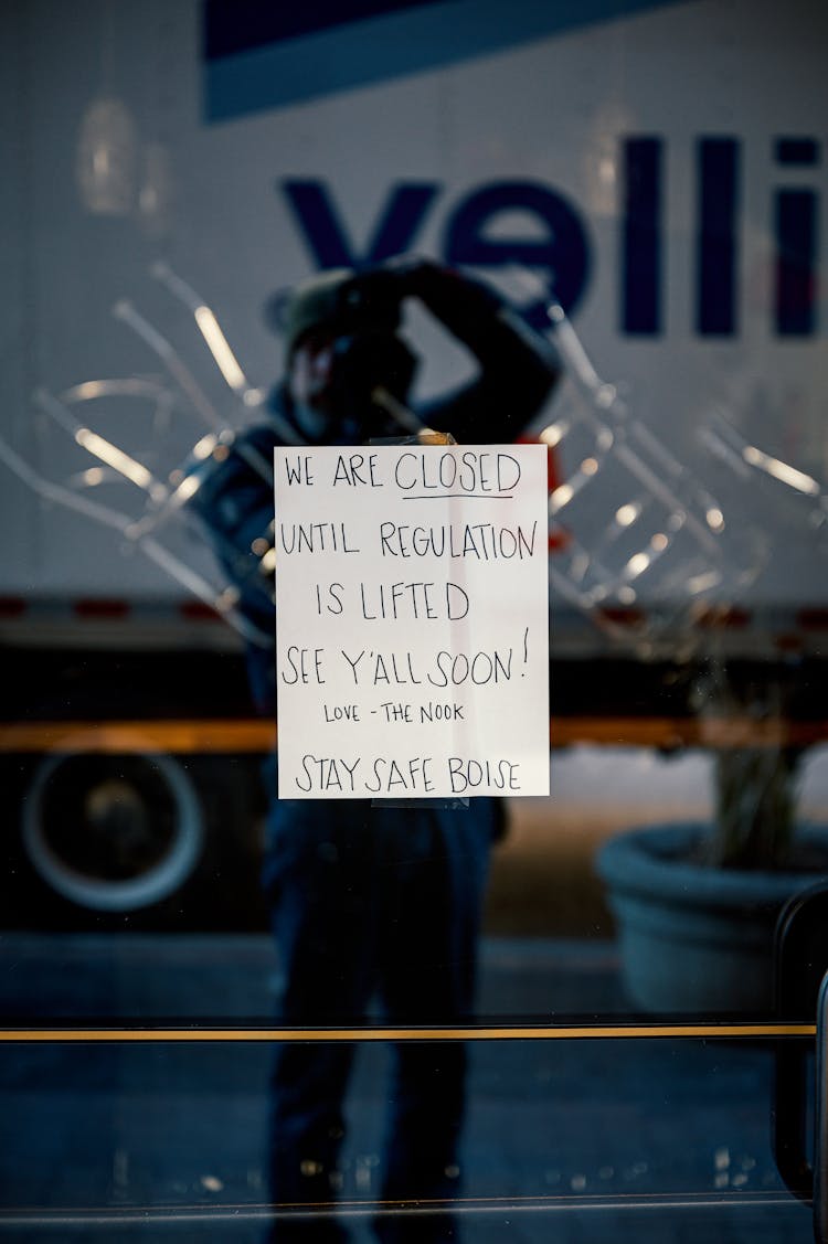 Closed Sign On Shop Glass Door Reflecting Photographer